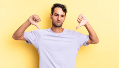 Hispanik yakışıklı adam üzgün görünüyor, anlaşmazlıkta parmaklarını gösteriyor.