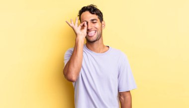 İspanyol yakışıklı adam mutlu bir şekilde gülümsüyor, şaka yapıyor ve gözetleme deliğinden bakıyor.