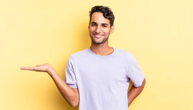 İspanyol yakışıklı adam gülümsüyor, kendine güveniyor ve konsept ya da fikir gösteriyor.