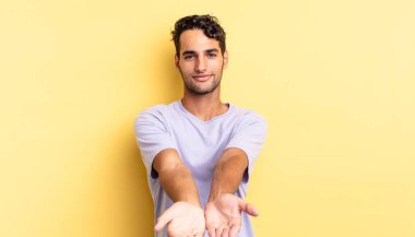 İspanyol yakışıklı adam mutlu bir şekilde gülümsüyor ve bir konsept sunuyor.