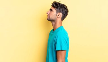 İspanyol yakışıklı adam profil görüşünde düşünüyor, hayal kuruyor ya da hayal kuruyor.