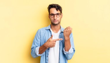 İspanyol yakışıklı adam sabırsız ve kızgın görünüyor, saati işaret ediyor.