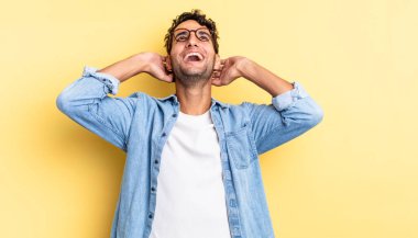 İspanyol yakışıklı adam gülümsüyor ve kendini rahat, tatmin olmuş ve kaygısız hissediyor.