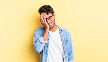 İspanyol yakışıklı adam gülüyor ve alnına tokat atıyor.