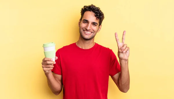 ヒスパニック系のハンサムな男は笑顔と幸せそうに見える勝利や平和をジェスチャー コーヒーの概念を取り上げ — ストック写真
