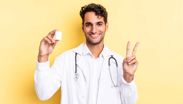 ヒスパニック系のハンサムな男笑顔と友好的に見える 2番目を示す 医師用ボトル薬のコンセプト — ストック写真