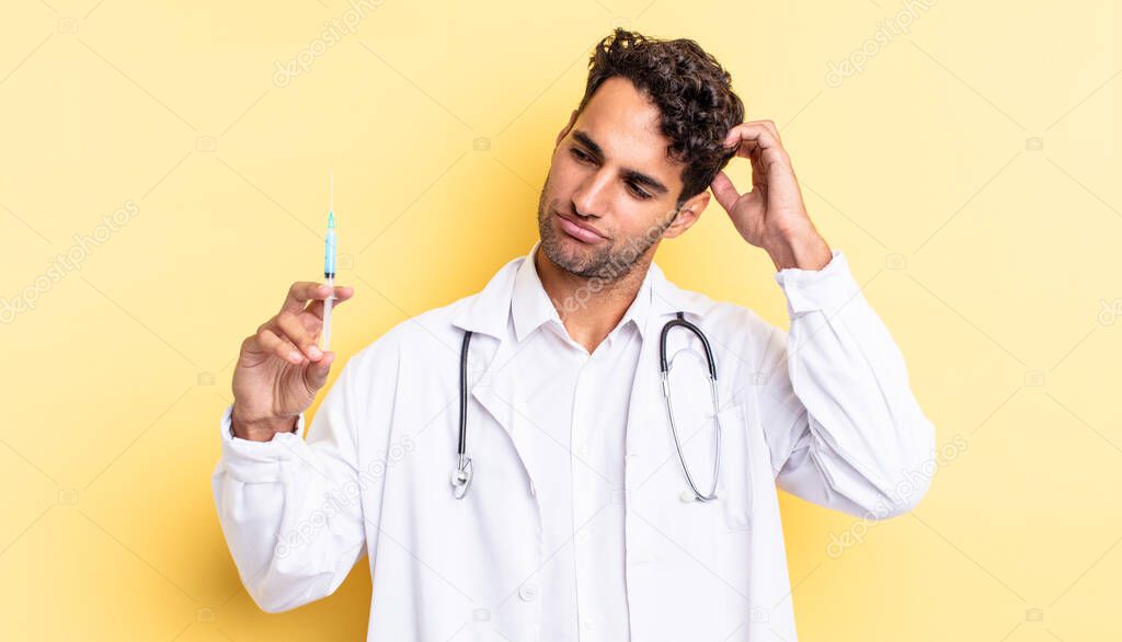hispanic handsome man feeling puzzled and confused, scratching head physician and srynge concept