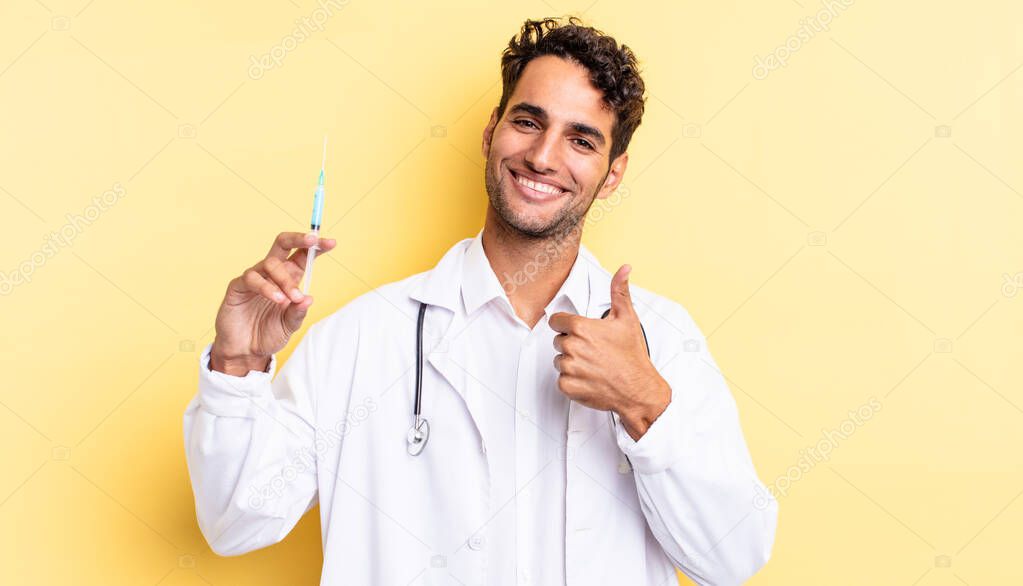 hispanic handsome man feeling proud,smiling positively with thumbs up physician and srynge concept