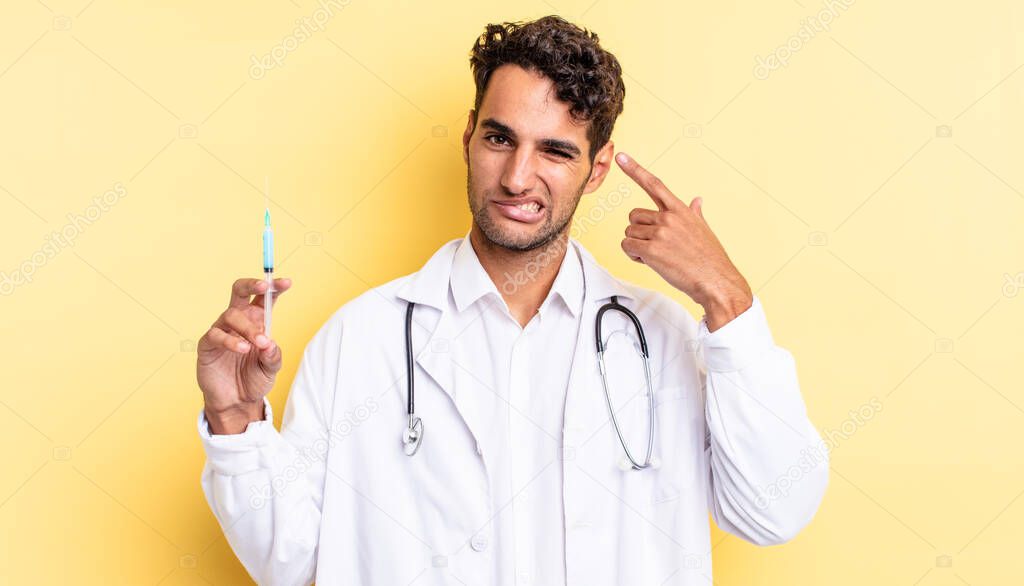hispanic handsome man feeling confused and puzzled, showing you are insane physician and srynge concept