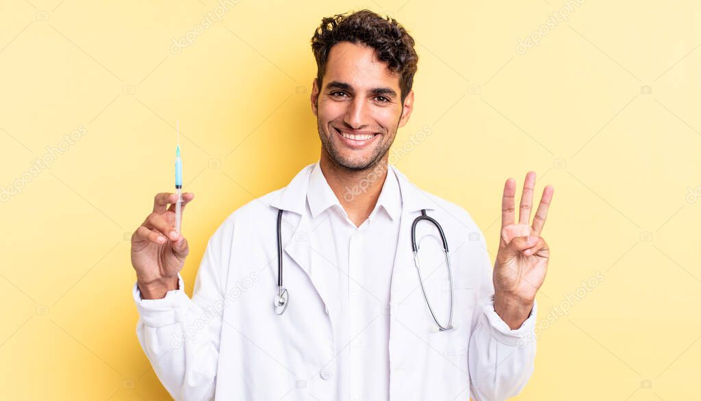 hispanic handsome man smiling and looking friendly, showing number three physician and srynge concept