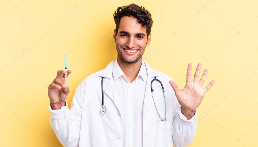 hispanic handsome man smiling and looking friendly, showing number five physician and srynge concept