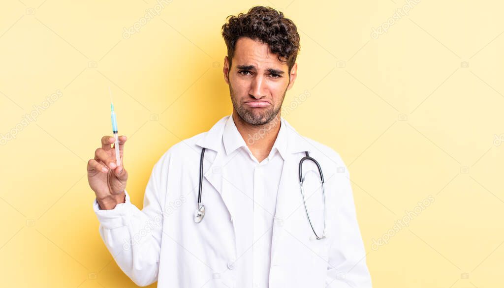 hispanic handsome man feeling sad and whiney with an unhappy look and crying physician and srynge concept