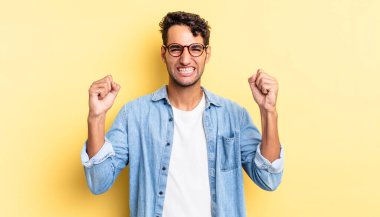 İspanyol yakışıklı adam mutlu, şaşırmış, bağırıyor ve başarıyı kutluyor.