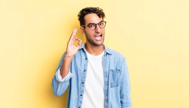 İspanyol yakışıklı adam kendini başarılı ve tatmin olmuş hissediyor, ağzı açık gülümsüyor.