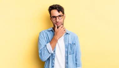 İspanyol yakışıklı adam ciddi görünüyor, kafası karışık, kararsız ve düşünceli.