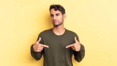 İspanyol yakışıklı adam gururlu, pozitif ve iki eliyle göğsünü gösteren