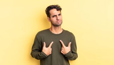 İspanyol yakışıklı adam, şaşkın ve tuhaf bakışlarıyla kendini işaret ediyor.