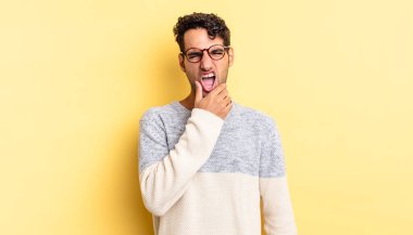 Ağzı ve gözleri açık, eli çenesinde İspanyol yakışıklı bir adam.