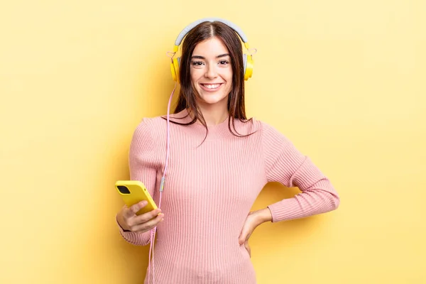 Νεαρή Ισπανίδα Χαμογελά Ευτυχισμένη Χέρι Στο Γοφό Και Αυτοπεποίθηση Ακουστικά — Φωτογραφία Αρχείου