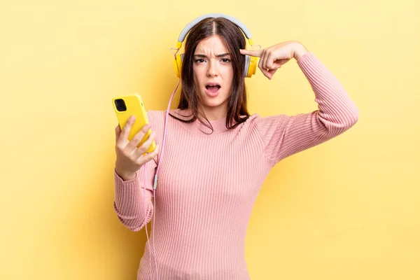 Young Hispanic Woman Feeling Confused Puzzled Showing You Insane Headphones — Stock Photo, Image