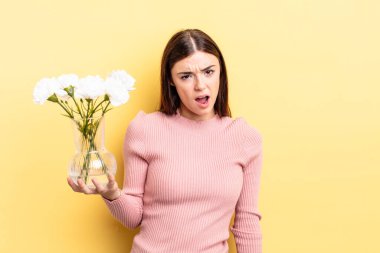 Genç İspanyol kadın şaşkın ve şaşkın hissediyor. saksı konsepti