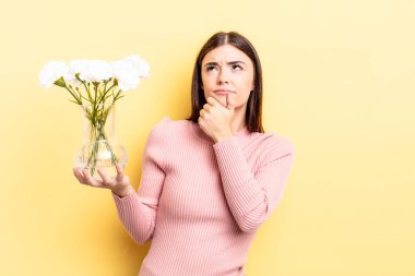 Genç İspanyol kadın düşünüyor, kuşkulu ve şaşkın hissediyor. saksı konsepti