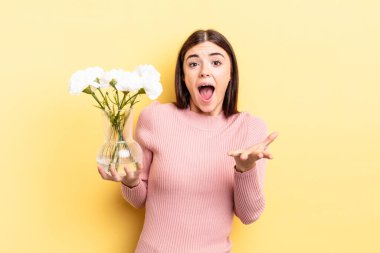 Genç İspanyol kadın şok olmuş ve şaşırmış hissediyor. saksı konsepti