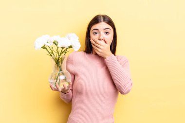 Genç İspanyol kadın şok olmuş ellerle ağzını kapatıyor. saksı konsepti