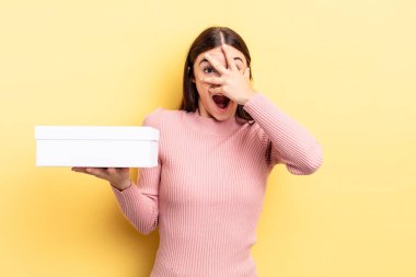 Genç İspanyol bir kadın şok olmuş, korkmuş ya da korkmuş görünüyor. Yüzü elle kapatılmış. boş kutu kavramı