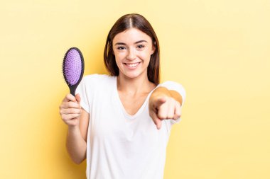 Genç İspanyol kadın kamerayı göstererek seni seçiyor. saç fırçası konsepti