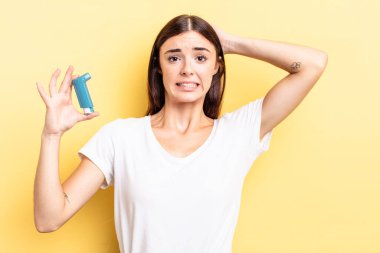 Genç İspanyol kadın stresli, endişeli ya da korkmuş hissediyor, elleri başının üstünde. astım konsepti