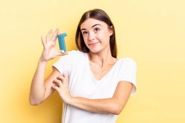 Genç İspanyol kadın omuz silkiyor, kafası karışık ve kararsız. astım konsepti