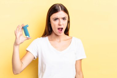 Genç İspanyol kadın şaşkın ve şaşkın hissediyor. astım konsepti