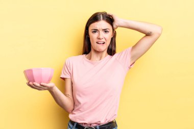 Genç İspanyol kadın stresli, endişeli ya da korkmuş hissediyor, elleri başının üstünde. boş kase kavramı