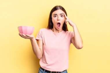 Genç İspanyol kadın şaşırmış görünüyor, yeni bir düşünce, fikir ya da konsept keşfediyor. boş kase kavramı