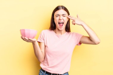 Genç İspanyol kadın mutsuz ve stresli görünüyor, intihar jesti silah işareti yapıyor. boş kase kavramı