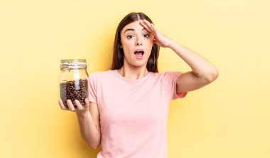 Genç İspanyol kadın mutlu, şaşkın ve şaşırmış görünüyor. kahve çekirdeği konsepti