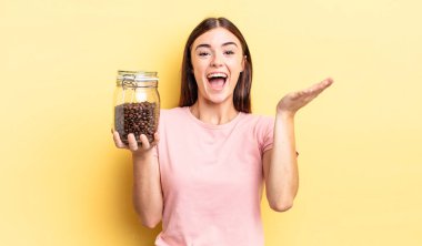 Genç İspanyol kadın kendini mutlu hissediyor ve inanılmaz bir şeye hayret ediyor. kahve çekirdeği konsepti