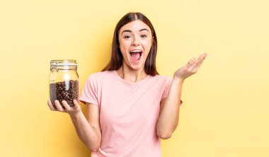 Genç İspanyol kadın kendini mutlu hissediyor, bir çözüm ya da fikir bulduğuna şaşırıyor. kahve çekirdeği konsepti