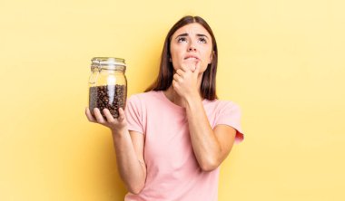 Genç İspanyol kadın düşünüyor, kuşkulu ve şaşkın hissediyor. kahve çekirdeği konsepti