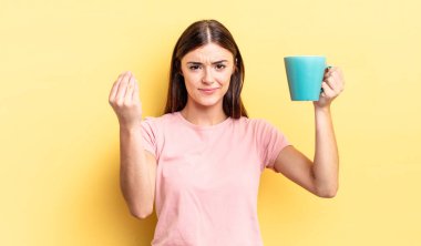 Genç İspanyol kadın kapiş ya da para hareketi yapıyor, sana ödemeni söylüyor. Kahve fincanı konsepti