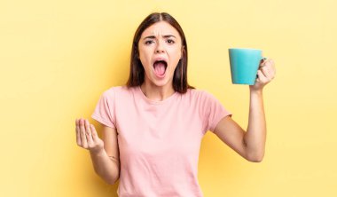 Genç İspanyol kadın kızgın, sinirli ve hayal kırıklığına uğramış görünüyor. Kahve fincanı konsepti