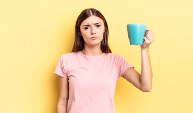 Genç İspanyol kadın üzgün ve mızmızlanıyor. Mutsuz bir bakışı var ve ağlıyor. Kahve fincanı konsepti