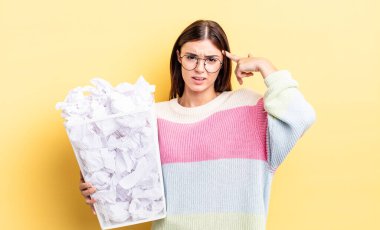 Genç İspanyol kadın şaşkın ve şaşkın hissediyor, senin deli olduğunu gösteriyor. başarısızlık çöp konsepti