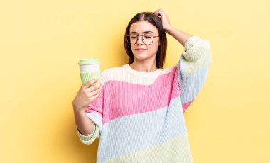 Genç İspanyol kadın şaşkın ve kafası karışık, kaşınan bir kafa hissediyor. kahve konseptini kaldır.