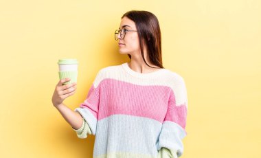 Profil görünümlü genç İspanyol kadın hayal mi kuruyor yoksa hayal mi kuruyor? kahve konseptini kaldır.