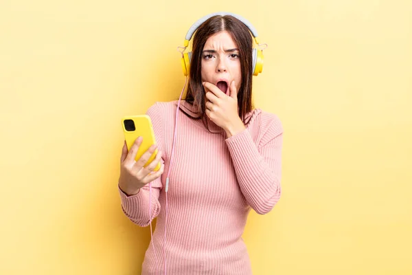 Young Hispanic Woman Mouth Eyes Wide Open Hand Chin Headphones — Stock Photo, Image