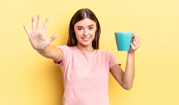 年轻的惊慌失措的女人面带微笑 看上去很友善 表现得第五 咖啡杯概念 — 图库照片