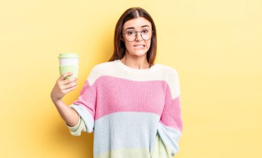 Genç İspanyol kadın şaşkın ve şaşkın görünüyor. kahve konseptini kaldır.