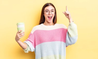 Genç İspanyol kadın bir fikri fark ettikten sonra mutlu ve heyecanlı bir dahi gibi hissediyor. kahve konseptini kaldır.